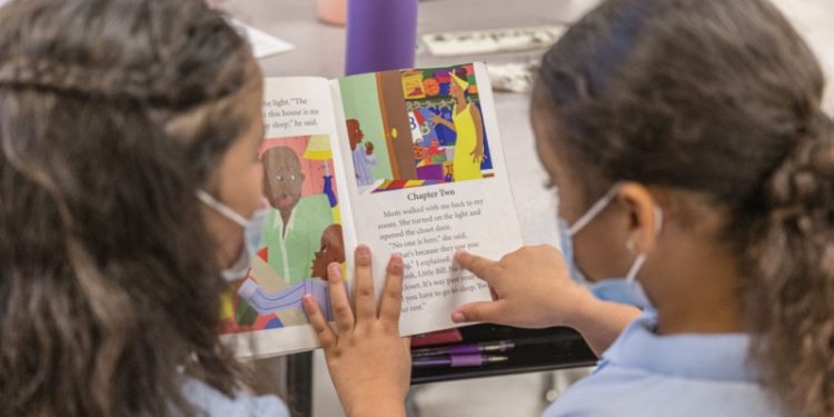 兩位孩童正在學校裡看書。（Getty Images）