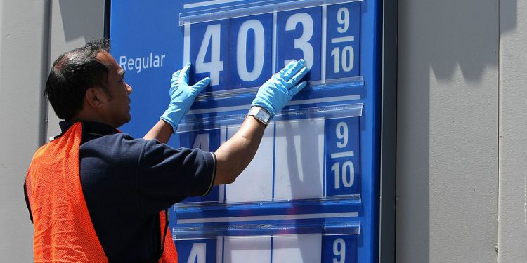 加油站工人正在更新油價的告示牌。（Getty Images）