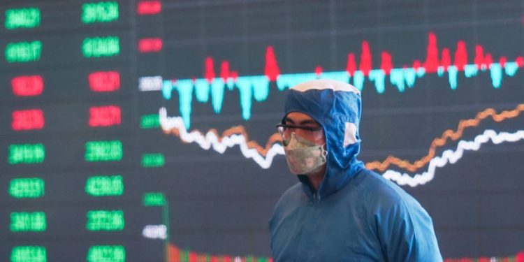 圖為2020年4月21日，上海證券交易所大廈中的一名工作人員戴着防護口罩。(圖片：Yves Dean/Getty Images)