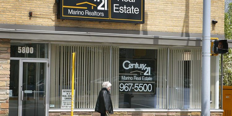 一位民眾經過Century 21 Real Estate房地產經紀公司門口。 （Getty Images）