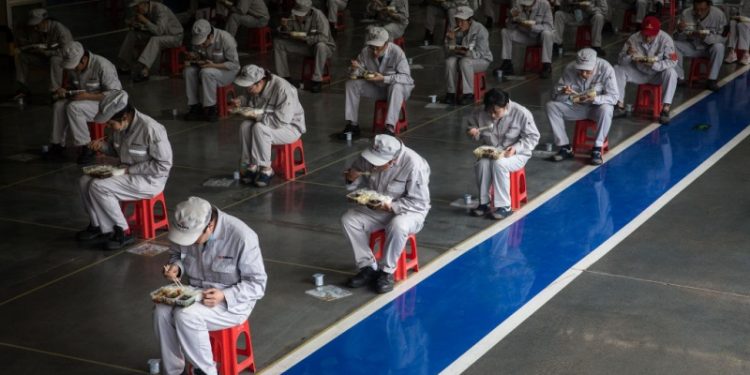 中國的防疫人員被排列起來進食。（Getty Images）