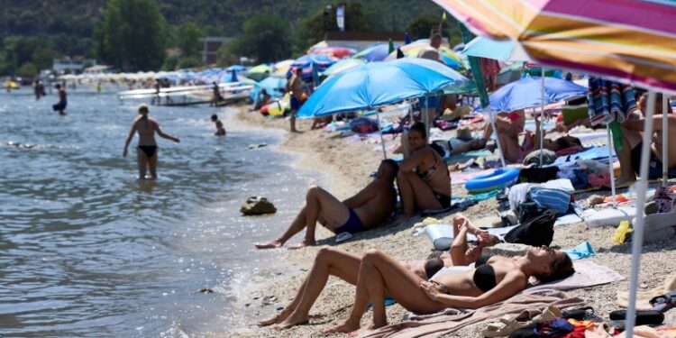 人群在高溫下的海邊遊憩。（REUTERS）